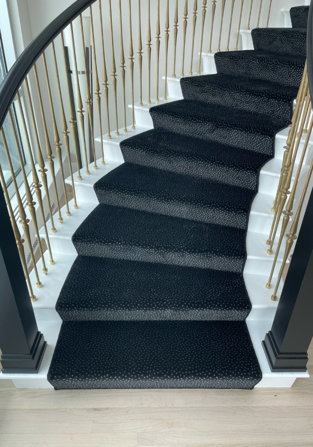 White spiral stairs with black carpeting. 